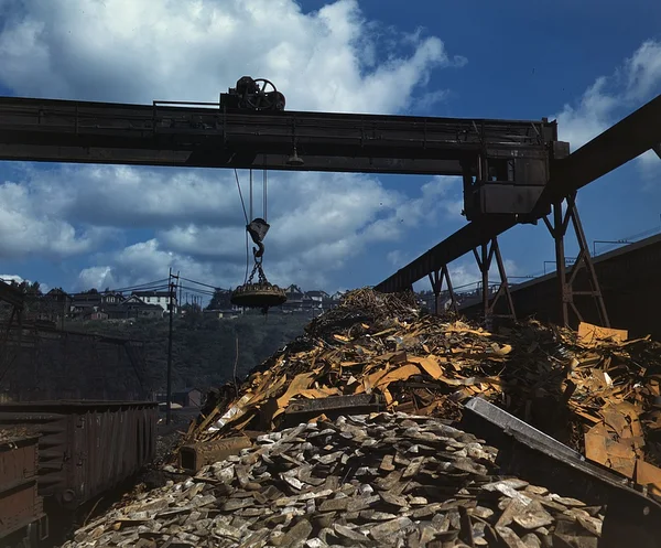 A heap of scrap metal beneath an overhead crane at a steel mill scrapyard, Pennsylvania, 1941